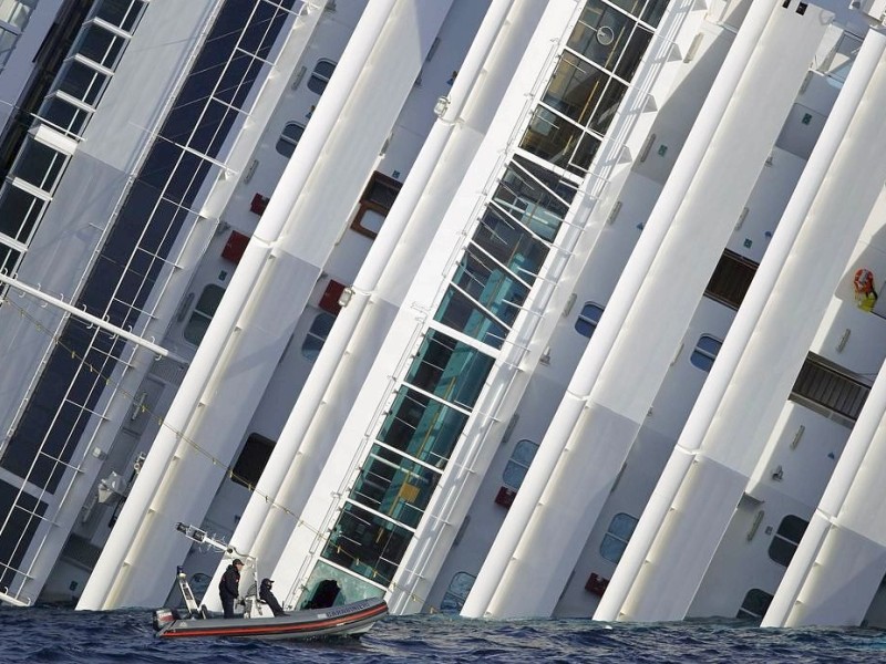 Members of the Carabinieri in a boat travel past the Costa Concordia cruise ship which ran aground off the west coast of Italy at Giglio island January 19, 2012. No deadline has been set for ending the search for missing people on the wreck of the Italian cruise liner that capsized off the Tuscan island, the chief spokesman of the firefighters said on Thursday.  REUTERS/Paul Hanna  (ITALY - Tags: DISASTER TRANSPORT)