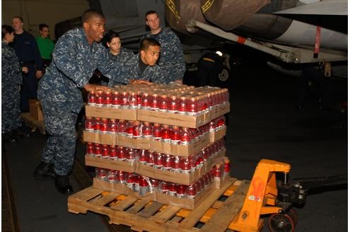 Internationale Rettungseinsätze laufen. Hier bereiten Marinesoldaten auf dem US-Flugzeugträger USS Ronald Reagan Getränkepaletten für den Transport in die Notstandsgebiete vor.