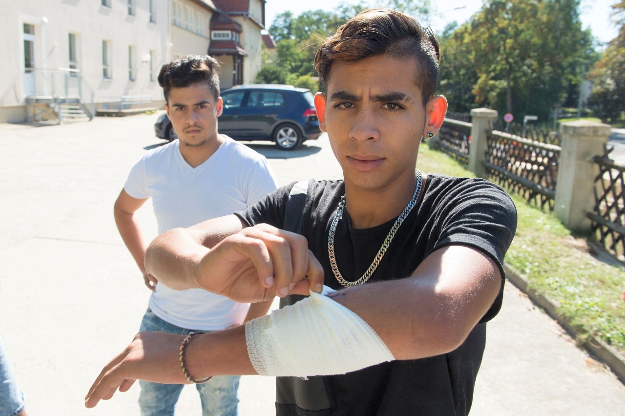 Mehdi (rechts) aus Marokko zeigt eine Schnittverletzung, die er sich nach eigenen Angaben bei den tätlichen Übergriffen Mittwochabend zugezogen hat.