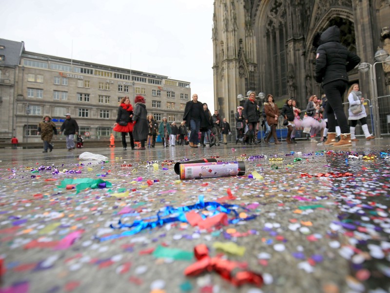 Nur das Wetter mag nicht so recht mitspielen. Vor dem Kölner Dom liegt Konfetti im Regen auf dem Boden.