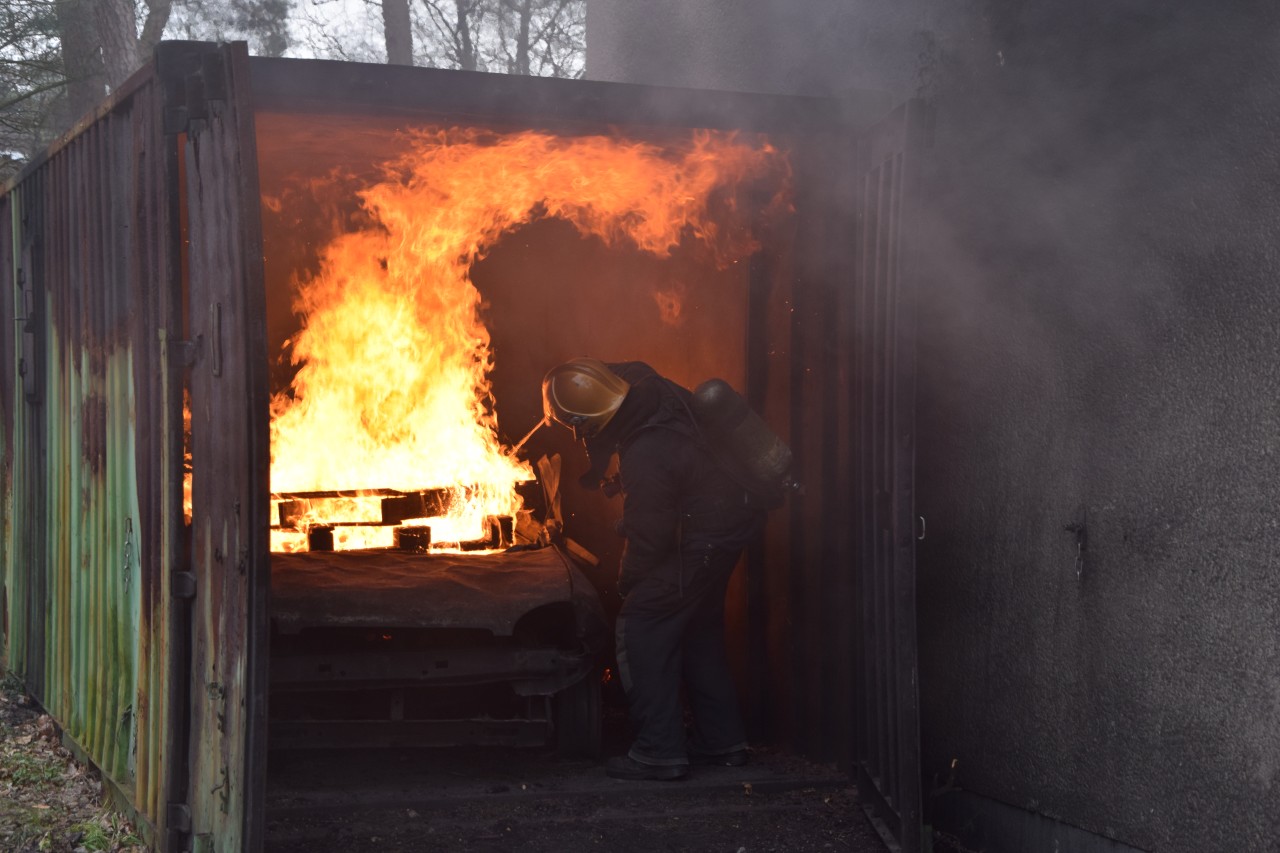 Neben dem Haus steht ein Container, der als Garage dient. Hier wird ein Übungsfeuer entfacht, damit das Haus richtig verraucht ist.