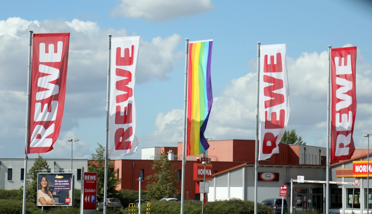 Vor den Märkten von Rewe stehen bereits seit 2016 Regenbogenfahnen. 