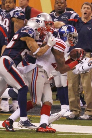 New York Giants wide receiver Mario Manningham makes a long catch inbounds past New England Patriots free safety Patrick Chung and free safety Nate Jones in the NFL Super Bowl XLVI football game in Indianapolis, Indiana, February 5, 2012.  REUTERS/Jim Young (UNITED STATES  - Tags: SPORT FOOTBALL)