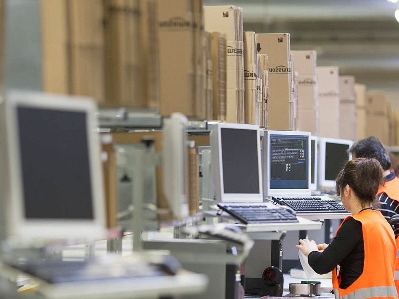 Arbeiterinnen und Arbeiter verpacken Ware, offizielle Einweihung des Amazon - Logistikzentrums in Rheinberg am Freitag, 17.02.2012. Foto: Bernd Lauter / WAZ FotoPool