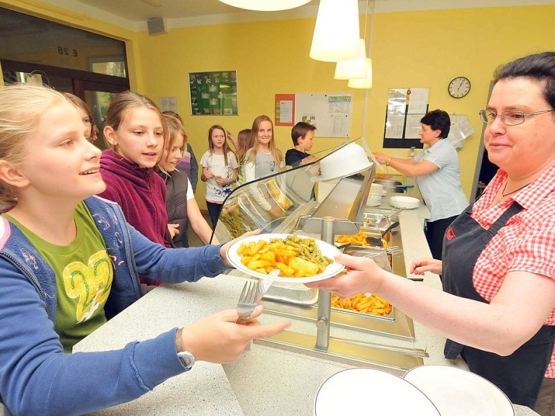 Großer Hunger, riesiger Andrang: DRK-Mitarbeiterin Gabriele Stumpe (50) gibt im „Ruhrcafé“ des Ruhr-Gymnasiums gerade Pommes mit Frikadellen aus.