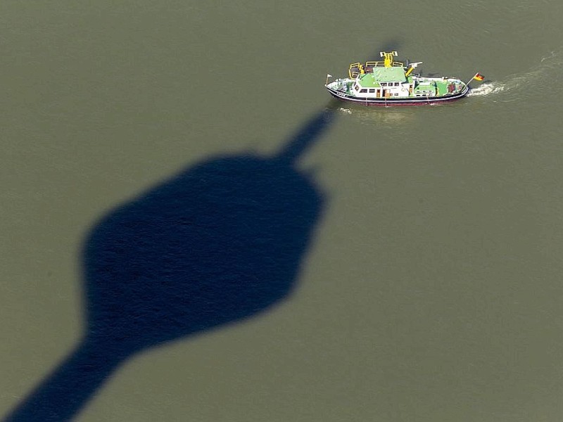 Der Riese Rheinturm wirft seine Schatten auf Vater Rhein.