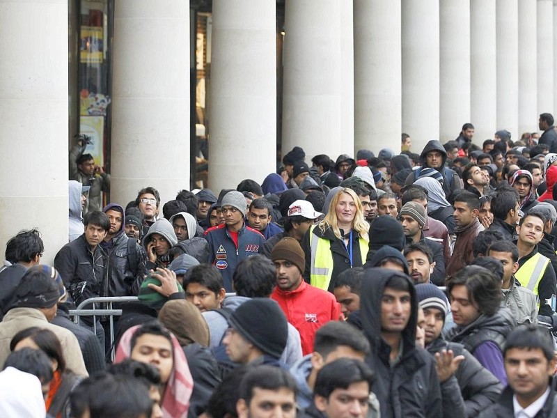 People queue to buy the new Apple iPhone 5 before the launch, at the Apple Store in Covent Garden in London September 21, 2012.     REUTERS/Luke MacGregor    (BRITAIN - Tags: BUSINESS TELECOMS)