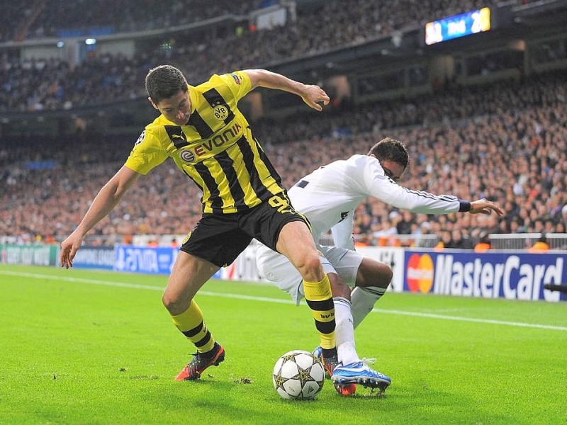 MADRID, SPAIN - NOVEMBER 06: Robert Lewandowski of Borussia Dortmund (L) battles for the ball against Raphael Verane of Real Madrid during the UEFA Champions League Group D match between Real Madrid and Borussia Dortmund at Estadio Santiago Bernabeu on November 6, 2012 in Madrid, Spain.  (Photo by Denis Doyle/Getty Images)