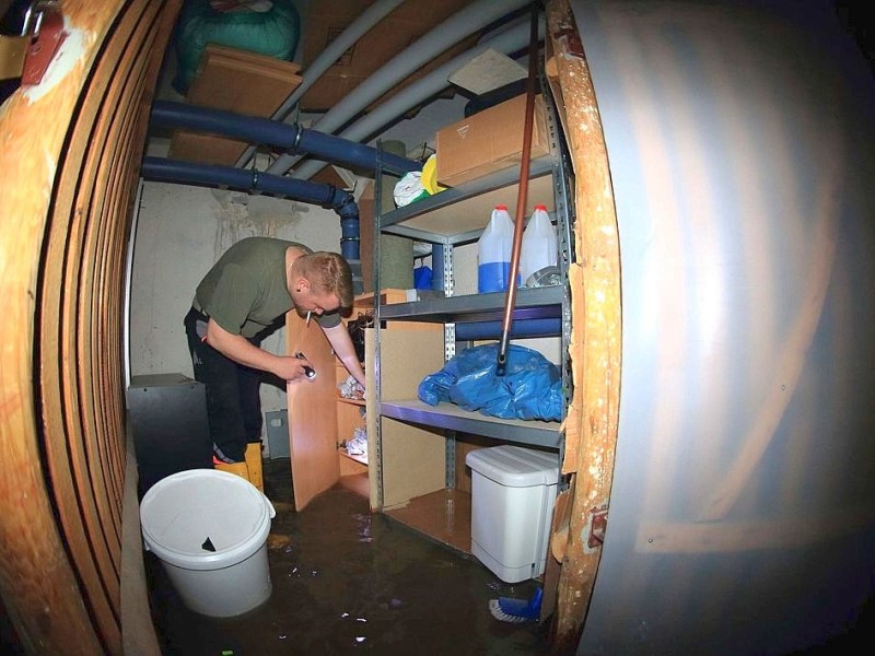 ...Sachsen-Anhalt begutachtet der Bewohner eines Hauses am Gimritzer Damm holt einige Dinge aus seinem durch das Hochwasser der Saale gefluteten Keller.