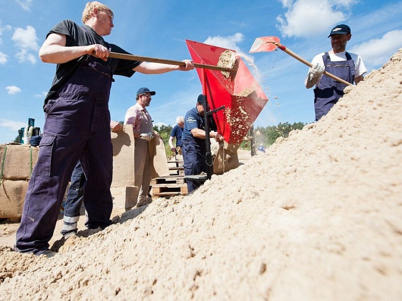 ...Helfer der Feuerwehr befüllten am Mittwoch in einer Kiesgrube nahe der niedersächsischen Ortschafft Tramm (Niedersachsen) Sandsäcke. Auch in Niedersachsen...