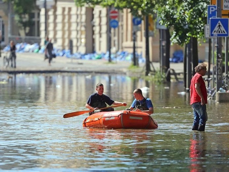 Mit dem Schlauchboot sind die Feuerwehrleute in Halle (Sachsen-Anhalt) unterwegs.