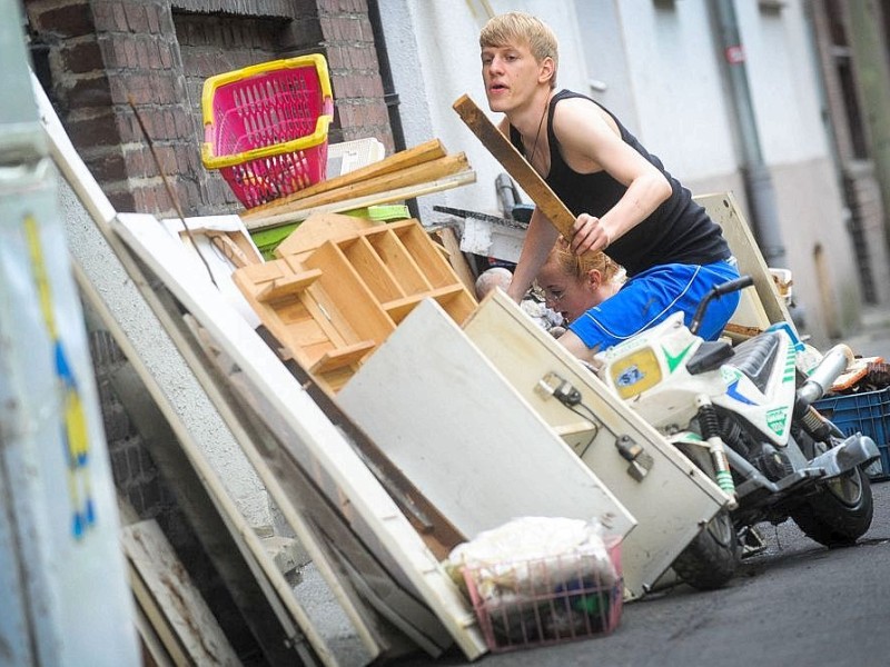Ab in den Sperrmüll: Am Tag nach dem Unwetter sind Bewohner dabei die Schäden zu sichten und mit den Aufräumungsarbeiten zu beginnen. Wie hier in Witten in der Herbeder Straße hat der Regen deutliche Spuren hinterlassen.