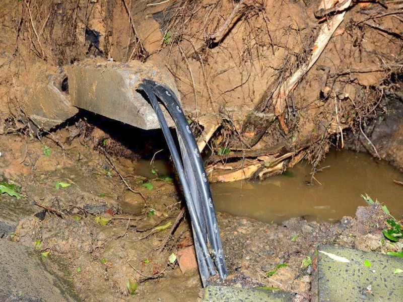 In den späten Abendstunden tobte ein extremes Unwetter über Bochum und hinterließ nach gut 30 Minuten ein totales Chaos. Im Bild: freigelegte Versorgungsleitungen der Telekom an der Bergstraße.