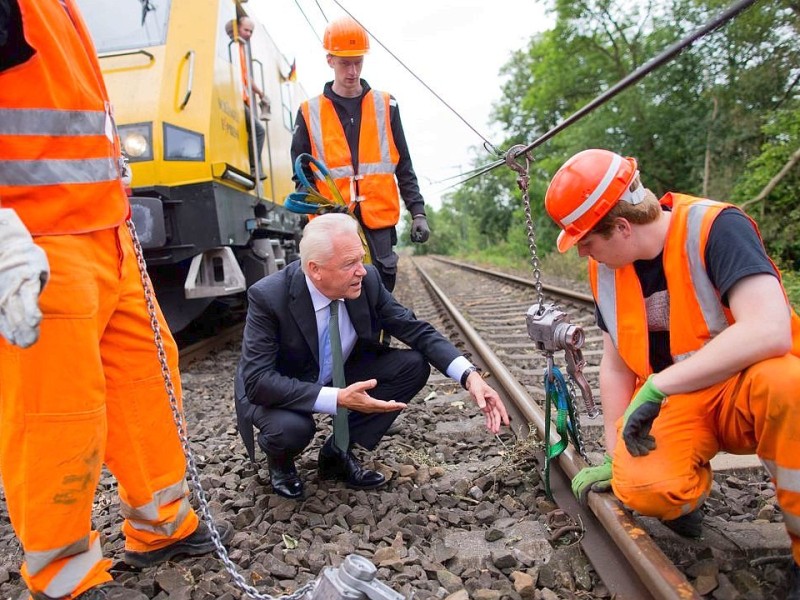 Der Vorstandsvorsitzende der Deutschen Bahn, Rüdiger Grube, unterhält sich am 16.06.2014 auf den Gleisen der S6 zwischen Düsseldorf und Essen in Ratingen (Nordrhein-Westfalen) mit Mitarbeitern. Foto: Rolf Vennenbernd