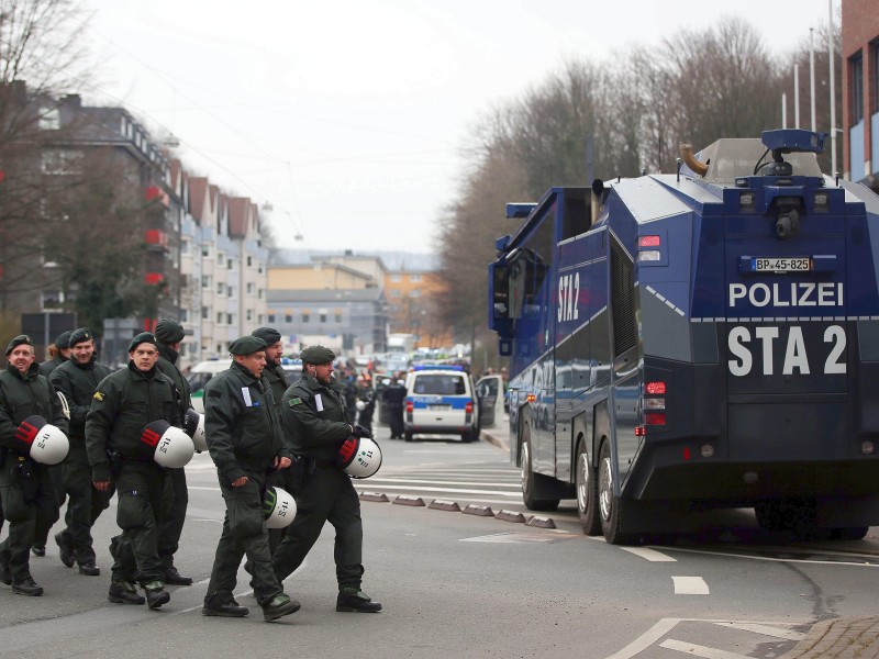 Polizisten und Wasserwerfer stehen in der Stadt.