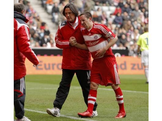 Franck Ribery wird von Mannschaftsarzt Hans-Wilhelm Müller-Wohlfahrt (beide Bayern, li.) beim Verlassen des Feldes gestützt. Foto: imago