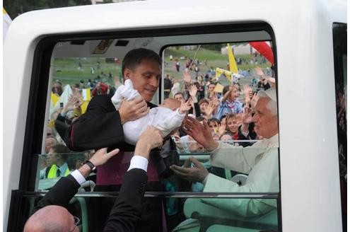 Währendessen segnet sein Herrchen ein Baby im Papamobil in Lourdes.