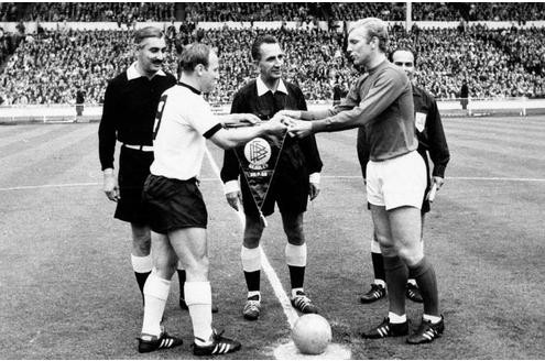 Ein Endspiel für die Ewigkeit: Bei der WM 1966 treffen Deutschland und England im Wembley-Stadion aufeinander. Uwe Seeler (links) und Bobby Moore tauschen die Wimpel. Später werden Schiedsrichter Gottfried Dienst (Mitte) und Linienrichter Tofik Bachramov (links) im Fokus stehen.