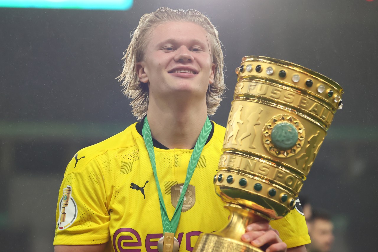 Haaland posiert stolz mit dem Pokal.