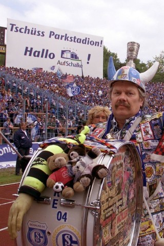 Peter Pollfuß:
In der linken Hand die Glocke, in der Rechten den Paukenschlägel - auf dem Kopf einen Helm mit wechselnden Figuren und eine Kutte bis zum Boden: Peter Pollfuß karrte zu den Schalker Heimspielen über Jahrzehnte beinahe mehr Utensilien an als Kohle im Ruhrgebiet gefördert wurde. Von 1990 bis 2009 war der gelernte Tankwart der Chef-Trommler auf Schalke. 395 (!) Aufnäher zierten seine selbstgenähte Kutte. Zunächst in Block 4 des Parkstadions aktiv, stand er ab 1997 als Gründer der Trommler-Garde den einlaufenden Spielern auf dem Feld Spalier.