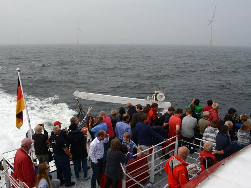 Passagiere schauen sich die ersten Windturbinen des Windparks Meerwind Süd/Ost an. Es ist die erste öffentliche Ausflugsfahrt per Schiff zu einem Offshore-Windpark vor Helgoland.