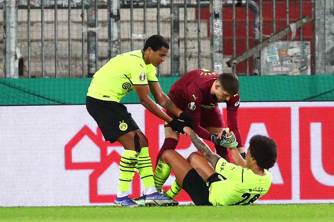 Manuel Akanji und Gregor Kobel helfen Witsel nach dessen Eigentor auf die Beine.