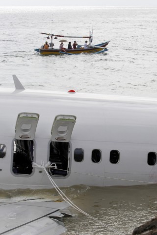 Ein Boot mit schaulustigen Touristen fährt an der Unglückstelle entlang.