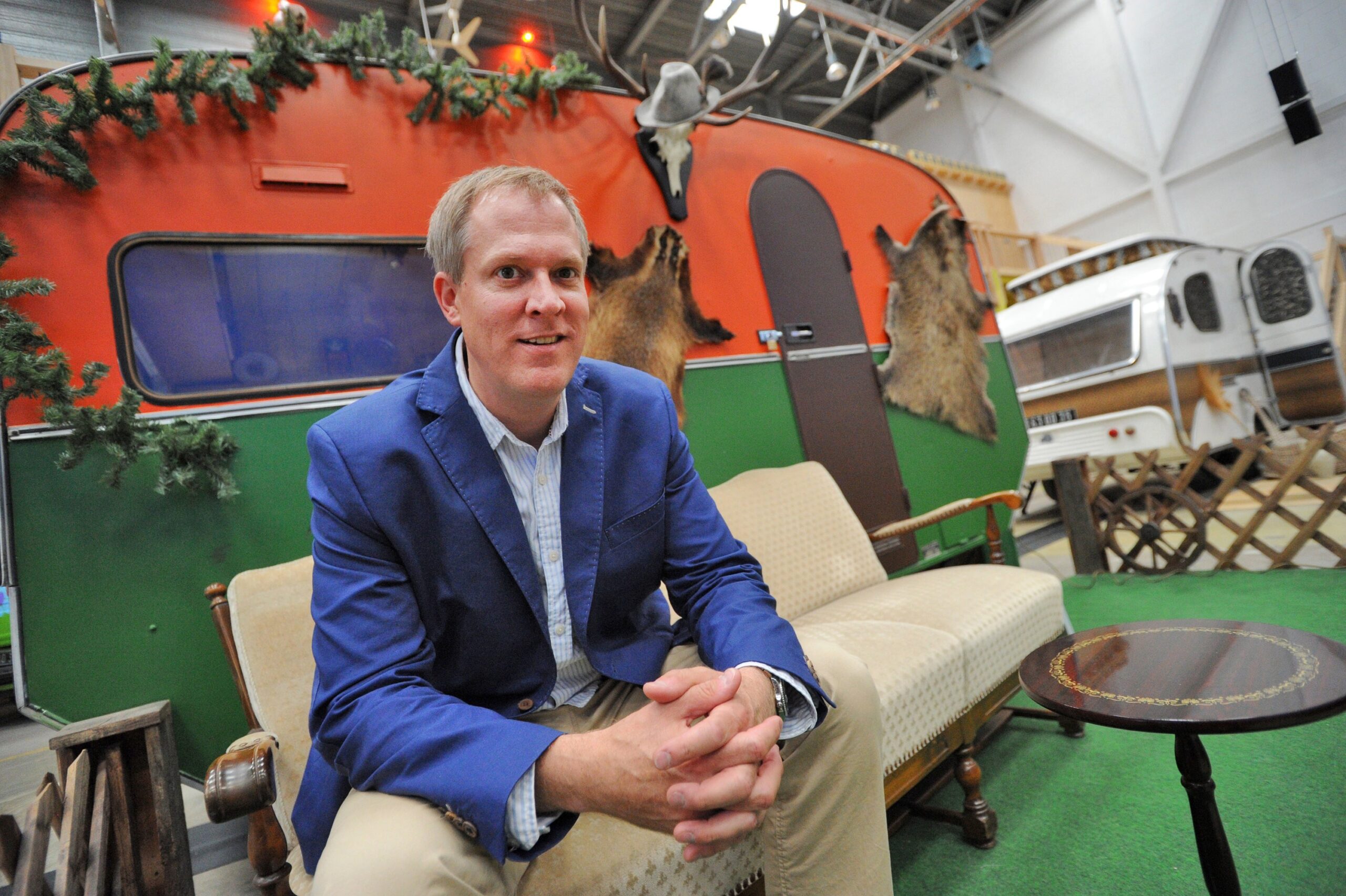 Hotelier Michael Schlößer sammelte die Retro-Campingwagen seines "BaseCamp"-Hostels in Bonn vor allem in den Niederlanden zusammen. Hier sitzt er vor dem Modell "Jägerhütte". 