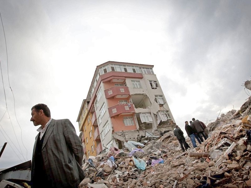 23. Oktober: Ein Erdbeben mit der Stärke 7,2 erschüttert die Gegend um die osttürkische Stadt Van. VAN, TURKEY - OCTOBER 26: People stand on ruins to look at damaged buildings after an earthquake, on October 26, 2011 in Van, Turkey. Media are reporting more than 400 people have been killed in the 7.2 earthquake that struck in Eastern Turkey on October 23. The earthquake has left up to 40,000 people homeless in almost freezing conditions. (Photo by Ahmad Halabisaz/Getty Images) *** BESTPIX ***