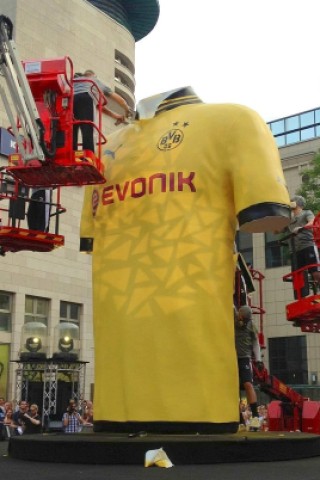 ...brachten unter den Augen von mehreren Tausend BVB-Fans zunächst immer mehr Details auf ein überdimensioniertes Trikot auf,...