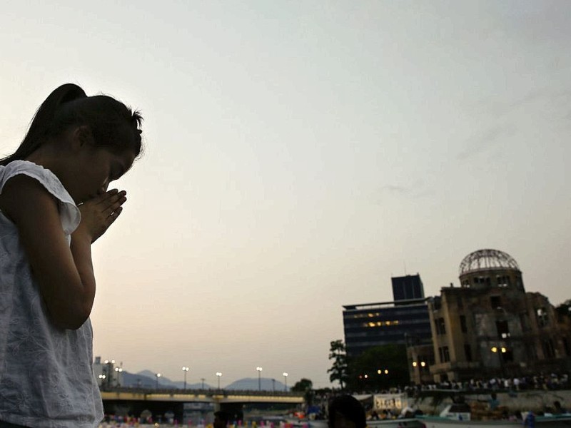 Viele Menschen gedenken  der Opfer des Atombombenabwurfs über Hiroshima vor 68 Jahren. Im Friedenspark steht noch immer eine Ruine als Mahnmal.