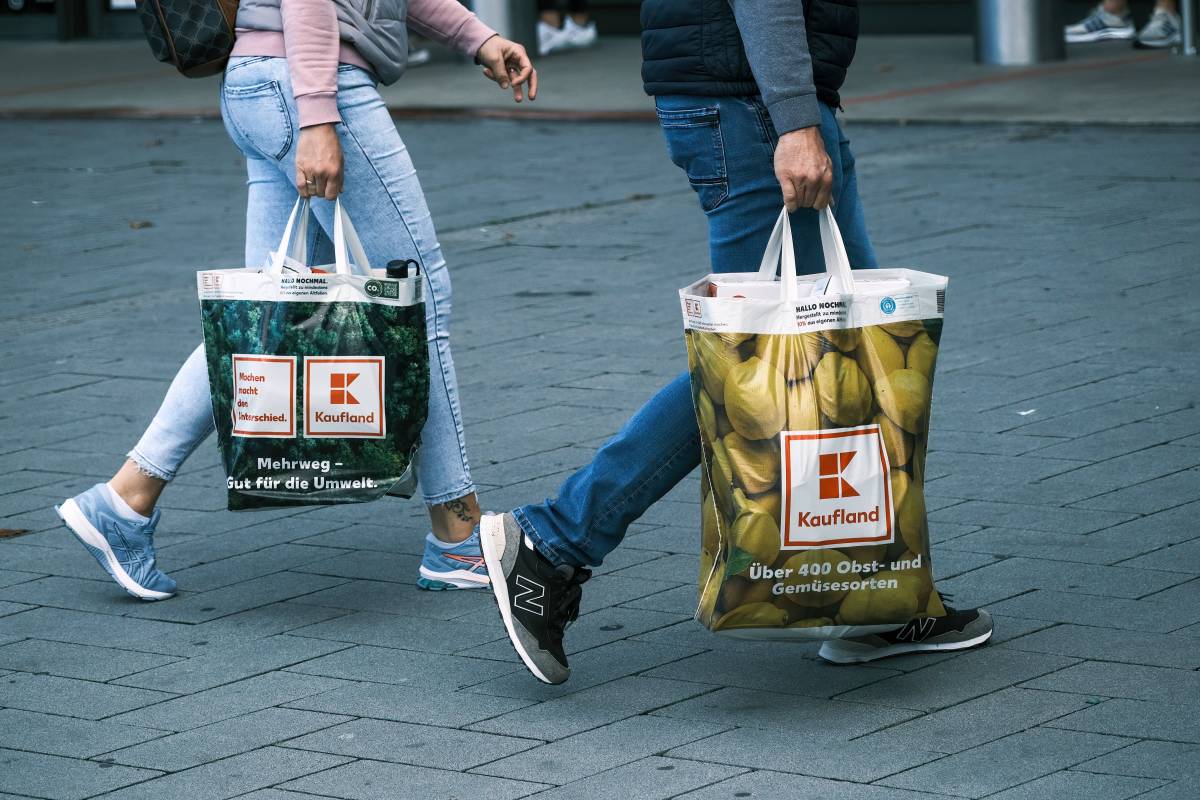 Zwei Menschen tragen ihre Einkäufe in Kaufland-Tüten.