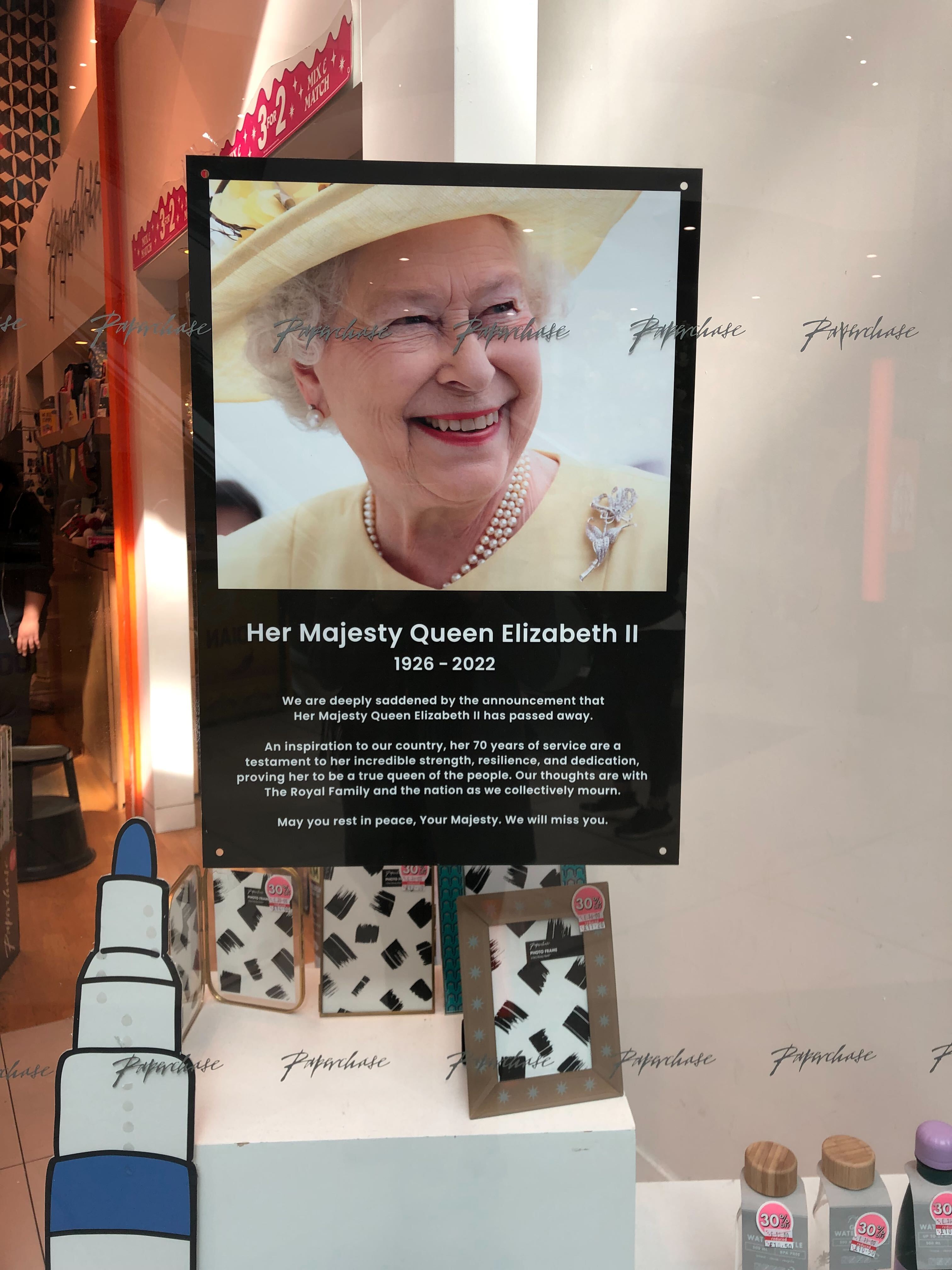 Im Schaufenster einer Papeterie wird Queen Elizabeth II. als "Inspiration für unser Land" betitelt.Und weiter: "Ihre 70 Dienstjahre sind ein Beweis für ihre unglaubliche Stärke, Belastbarkeit und Hingabe, die sie als wahre Königin des Volkes ausweisen. Unsere Gedanken sind bei der königlichen Familie und der ganzen Nation, während wir gemeinsam trauern."