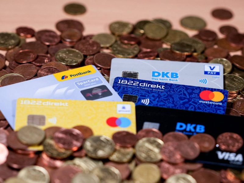 EC-Karten von der Postbank und der DKB liegen auf Kleingeld
