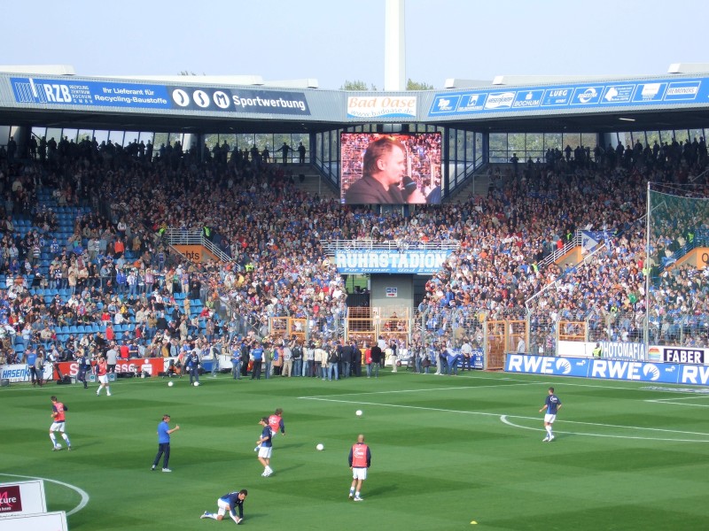 Frank Windhofer: Dieses Foto entstand am 14. Oktober 2006: An diesem Tag lud ich meinen Neffen zum Bundesligaspiel des VfL gegen Werder Bremen ein. Es war ein Geschenk zu seinem damaligen 10. Geburtstag. Ich war damals überrascht aber auch sehr glücklich, dass ausgerechnet an diesem Tag Herbert Grönemeyer im Stadion erschien und zum Ehrenmitglied des VfL (Mitgliedsnummer 4630!!) ernannt wurde. Nach einigem Zögern wurde er vom Publikum ermuntert Bochum zu singen. Live und vor einem Fussballspiel echt ein Erlebnis! Dass das Spiel 0:6 verloren ging, war für mich als Grönemeyer-Fan eher Nebensache, für meinen Neffen eine Katastrophe. Mit diesem unerwarteten Ereignis kehrte ich zurück und freute mich nun auf die Geburt meiner zwei Töchter, die nur wenige Tage später zur Welt kamen! Bochum ich komm aus Dir...