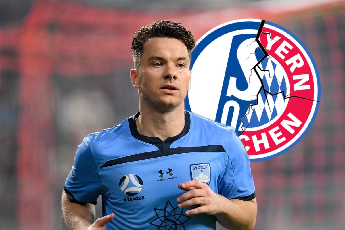 Alexander Baumjohann schaut auf die Wappen von Schalke und Bayern.