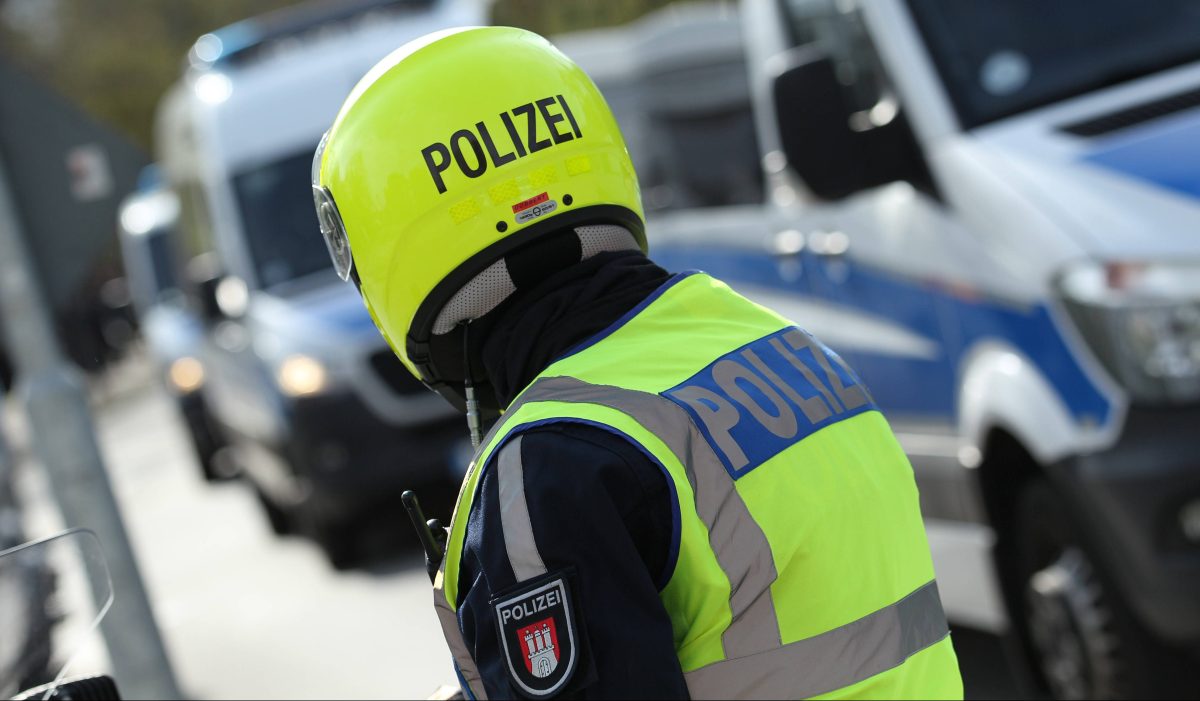 Polizist und Polizeiwagen im Hintergrund