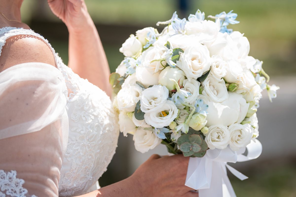 Braut in Kleid und mit Strauß in der Hand