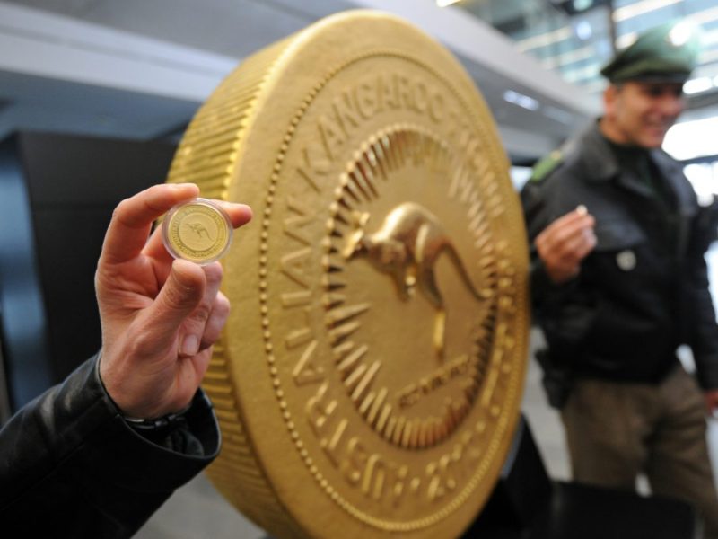 Eine Polizistin hält eine 30 Gramm schwere Münze vor die wohl teuerste Münze der Welt, der Red-Kangaroo-Goldmünze.