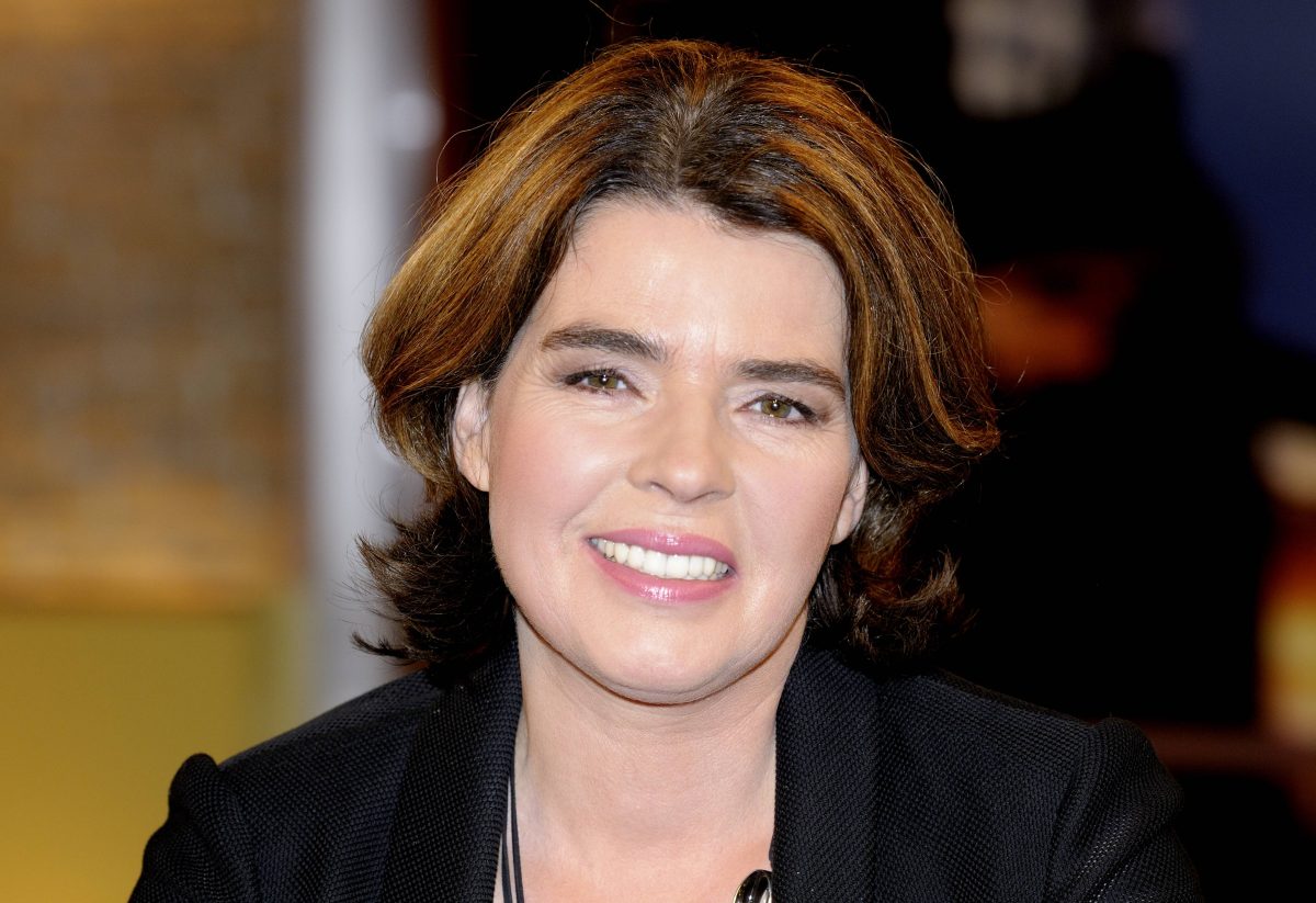 Auf dem Bild ist Fernsehmoderatorin Susanne Daubner zu sehen. Sie hat braune schulterlange Haare. Sie trÃ¤gt neben einem breiten Grinsen einen schwarzen Blazer.