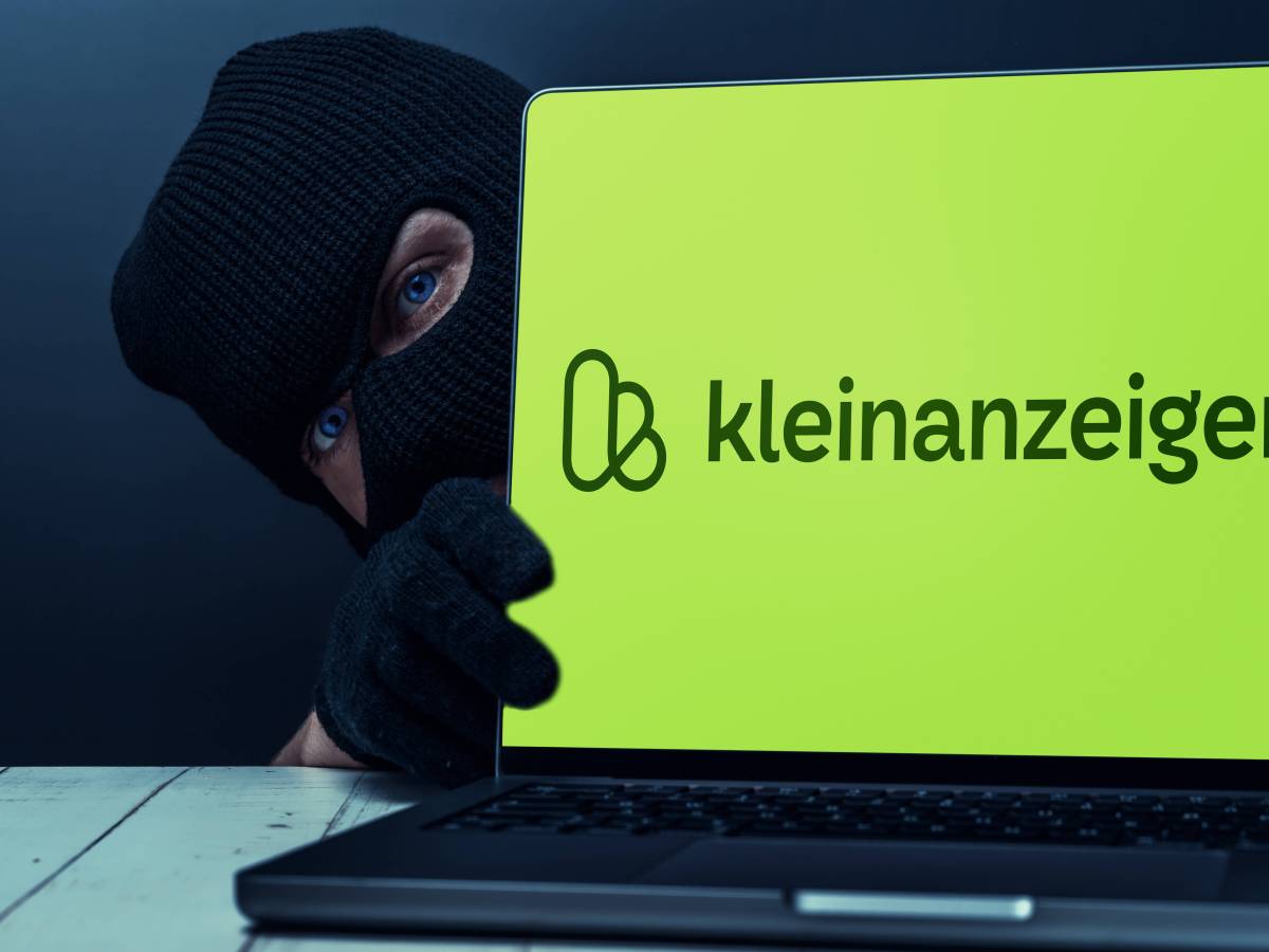 Ein Mann mit Skimaske versteckt sich hinter einem Notebook, auf dem das Verkaufsportal Kleinanzeigen geöffnet ist.