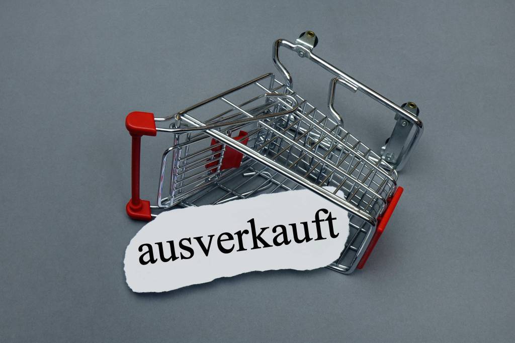 Ein umgekippter leerer Einkaufswagen mit einem Schriftzug "ausverkauft".