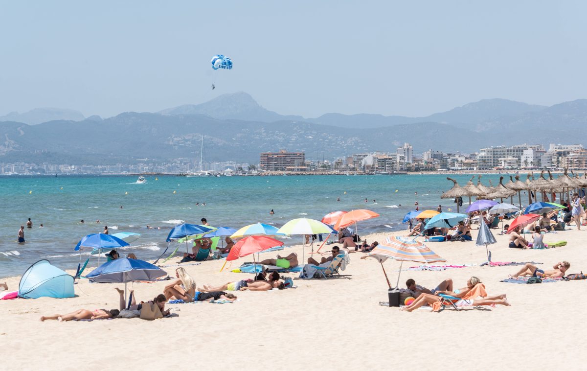 Menschen liegen an einem Strand auf Mallorca.