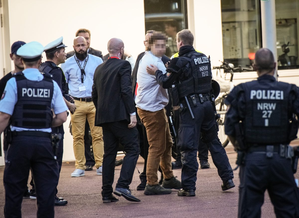 AfD in Essen: Ein Demonstrant wird aus der Philharmonie geführt.